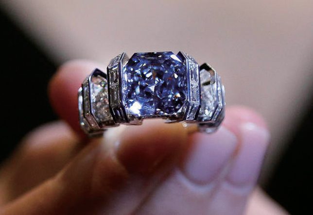 A model shows 'The Sky Blue Diamond' ring at the auction house Sotheby's in London, Tuesday, Oct. 11, 2016. The mesmerizing and rare vivid blue diamond weighs 8.01 carats, mounted by Cartier, will be on auction on Nov. 16, 2017 with an estimate of 15-25 million dollars (12-20 million pounds, 13.5-22.5 million euro). (AP Photo/Frank Augstein)